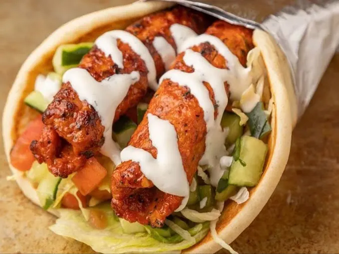 Chicken gyro wrap with white sauce, lettuce, tomato and cucumber