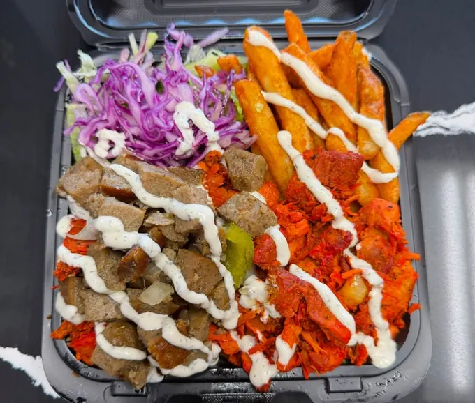 Combo platter with gyro and spicy chicken, seasoned fries, slaw and white sauce