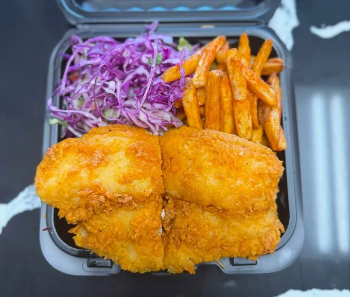 Fish platter with golden fried fish, seasoned fries and red cabbage slaw