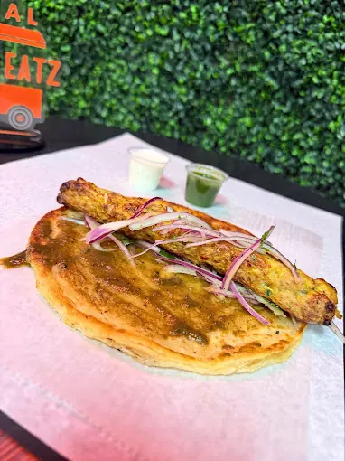 Seekh kebab on paratha with green chutney and red onions