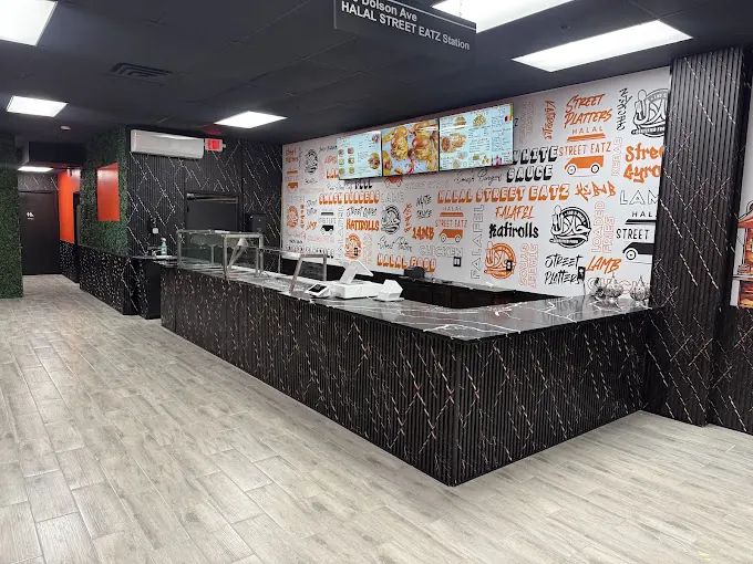 Halal Street Eatz counter with graffiti-style brand wall and menu screens